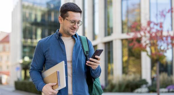 Eine Lehrkraft beobachtet und kontrolliert die Leistung ihrer Schüler am Smartphone.