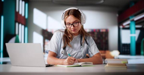 Eine Medizinstudentin übt konzentriert Vokabeln mit der Software Aprendo am Laptop.